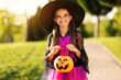 happy child girl in a carnival costume and with bucket on Halloween   outdoors.