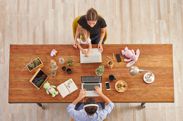 Couple working from home with them child, wooden table, laptop toy and lamp, up concept.