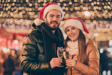 Sticker - Photo of two people couple toast champagne glass 2021 x-mas greeting under evening outside illumination wear santa claus cap