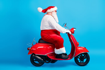 Wall Mural - Full length profile side photo of fat santa claus with big beard drive scooter x-mas christmas newyear wear stylish modern suspenders overalls hat isolated blue color background