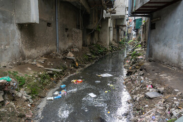 Dirty polluted waste water in big city with garbages. Environment pollution. Urban environment issues in developing countries