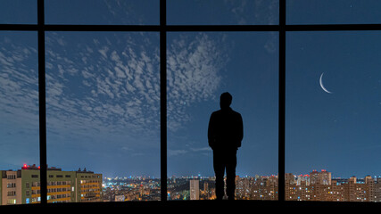 Wall Mural - The man standing near the window against the night city