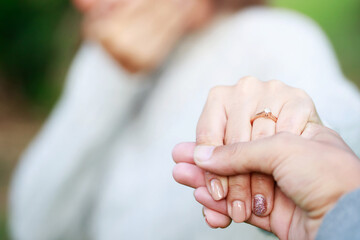 Wall Mural - Women and man wear a ring in the finger holding hands together, Happy love in the garden. romantic atmosphere in the parks. concept couple lover valentine day. shake hands