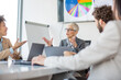 © Sanja - A group of business partners sit in a conference room and analyze the business of their corporations, the boss talking about new business
