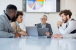 © Sanja - A group of business partners sit in a conference room and analyze the business