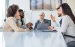 © Sanja - A group of business partners sit in a conference room, agreeing on new business moves