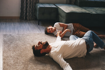 Wall Mural - Father and son in the living room lie on the floor and relax during the afternoon