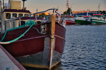 Poster - Sunset in the port. The concept of beautiful views over the sea. Moored boats and sailboats against the setting sun.