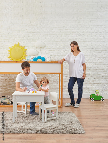 Happy family play game in the modern baby room style, wooden child object, bed white table, decorative brick wall background.