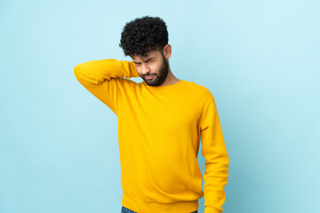 Young Moroccan man isolated on blue background with neckache