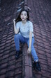© AndhikaRaya - The blonde girl sits on the roof tile while stylishly wearing a gray shirt. female t-shirt models for mockups and templates.