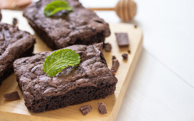 Top view of chocolate brownies on wooden board on white table, homemade sweet and dessert concept