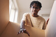 © AnnaStills - African young man stretching his hand and taking out the parcel from the box