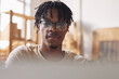 © AnnaStills - African young man in eyeglasses typing on laptop computer he working online at work