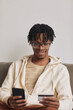 © AnnaStills - African smiling man using his mobile phone for online shopping and paying with his credit card
