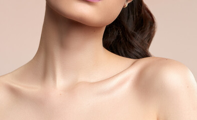 women's neck and shoulders skincare brown hair on a nude background