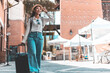 © Puwasit Inyavileart - Asian woman beaming carrying a suitcase black to travel on vacation, Trolley bag, Long weekend travel, Love the trip, Tourism festival concept.