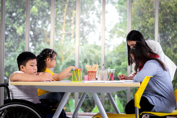 Wall Mural - Disabled kids classroom, children having fun during study at school, kids learning and playing together, school child having fun with teacher in classroom