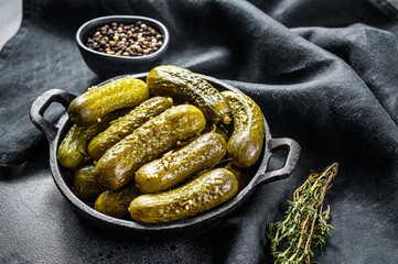 Plate of pickled homemade cucumbers, pickles. Black background. Top view