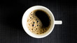 Xícara de café expresso sobre o tampo de madeira preta - Foto ao topo e perfil