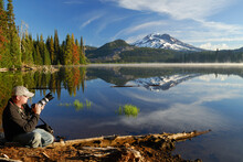 Photographer On Shore Of Calm Sparks Lake With South Sister Mountain