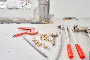 Tools for Work As A Plumber. Connection heating pipes to white Radiator in a new apartment under construction. water heating radiator on the white wall indoors