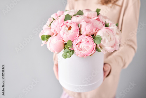 Round box with Bouquet of Pink peonies in a women hand. Beautiful peony flower for catalog or online store. Floral shop concept . Beautiful fresh cut bouquet. Flowers delivery