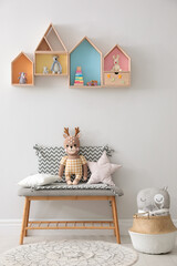 Wall Mural - House shaped shelves and bench with toys in children's room. Interior design