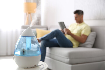 Poster - Modern air humidifier and blurred man on background