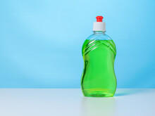 A Bottle Of Green Cleaning Gel On A White Table On A Blue Background.