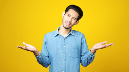 Young asian man doubting while standing over isolated yellow background, Portrait of confused handsome asia guy, People negative gusture expression