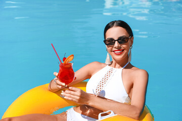 Sticker - Beautiful young woman relaxing on swimming ring in pool