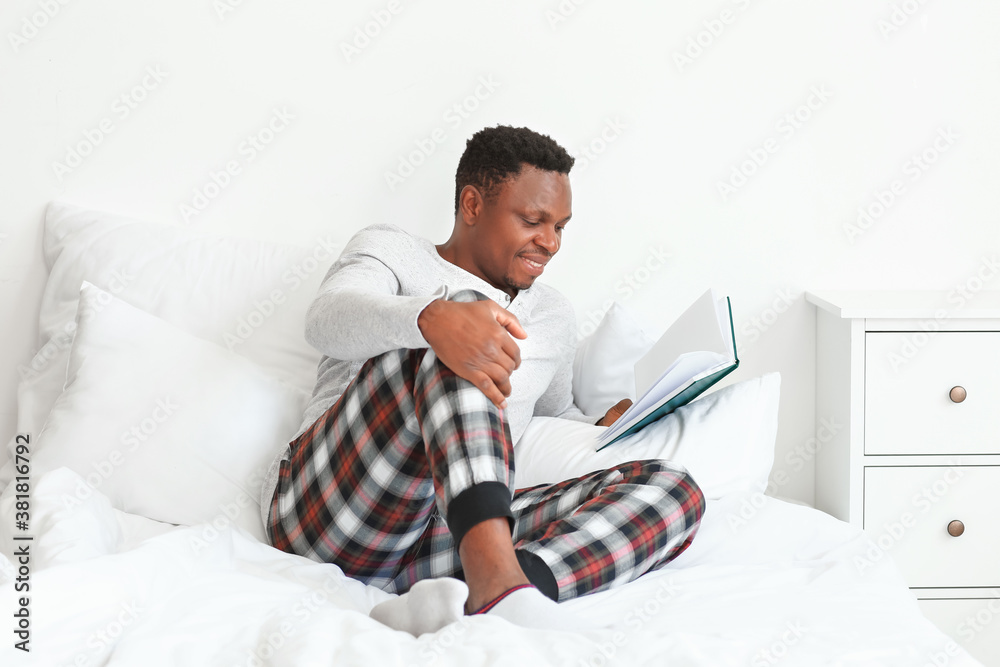 African-American man reading book at home