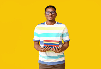 Wall Mural - African-American man with books on color background