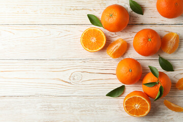 Ripe sweet mandarins on white wooden background, top view