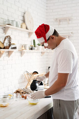 Wall Mural - Man in santa hat making meringue on white wooden table