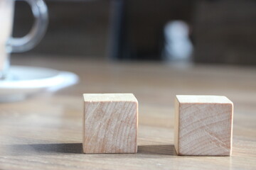 Two natural wooden cubes with coffee cup. Selective focus. Choise business concept