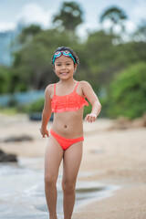 child relaxing on the beach against sea and sky background. summer vacation and travel concept. happy little girl running on the beach.