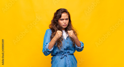 Fotografía looking confident, angry, strong and aggressive, with fists ready to fight in b