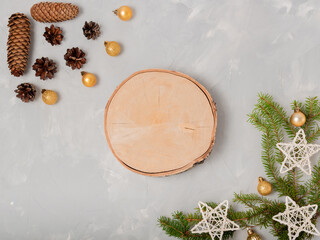 Wall Mural - Light New Year's composition. Pine cones, fir branches, festive stars and balls, wooden round saw cut in the center with space for product or text. Flat lay, top view