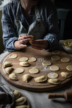 Step By Step Process Of Making Ukrainian Pyrogy (Polish Pierogi) With Cottage Cheese. Woman Making Pyrogy Sitting By The Table.
