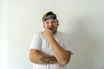 Wall Mural - Cool guy with a black bandana on his head while smiling and his left hand to his chin