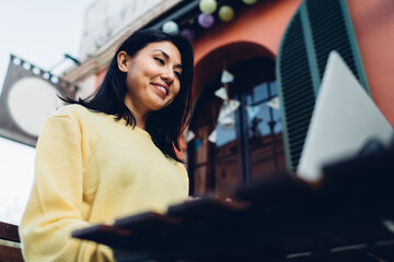 Canvas Print - Female freelancer using laptop in street cafe