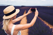 Cheerful young female tourist picturing lavender fields
