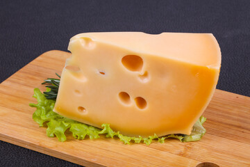 Maasdam cheese  in the board served salad leaves