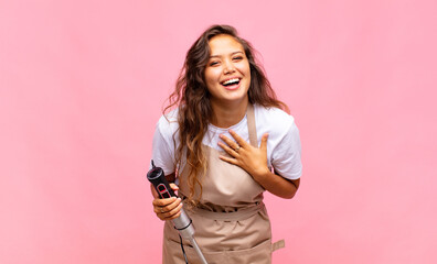 young woman baker laughing out loud at some hilarious joke, feeling happy and cheerful, having fun