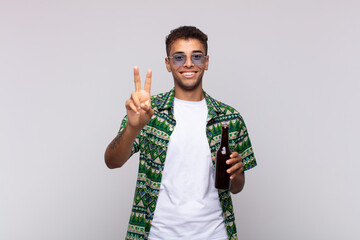 young south american man smiling and looking friendly, showing number two or second with hand forward, counting down