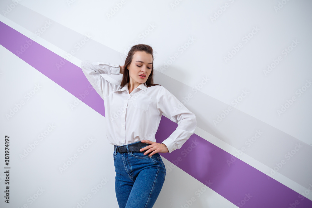 beautiful young white-skinned girl dressed in a white shirt and blue ...