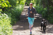 © Paul Bradbury/Caia Image - Woman jogging with dog on sunny trail