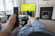 © Paul Bradbury/Caia Image - POV man on sofa with remote control watching soccer match on TV